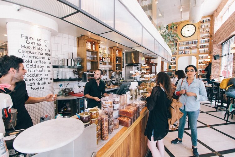 People queueing to order in a busy cafe.