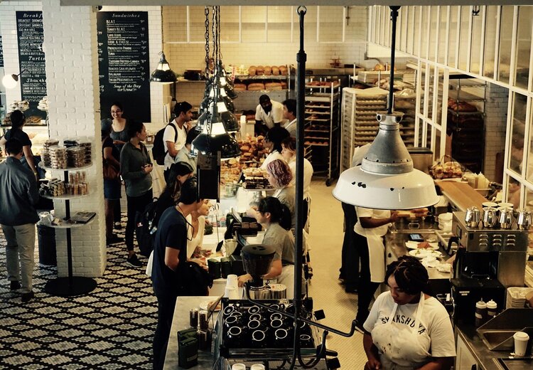 A busy cafe with customers queueing to pay at the counter.